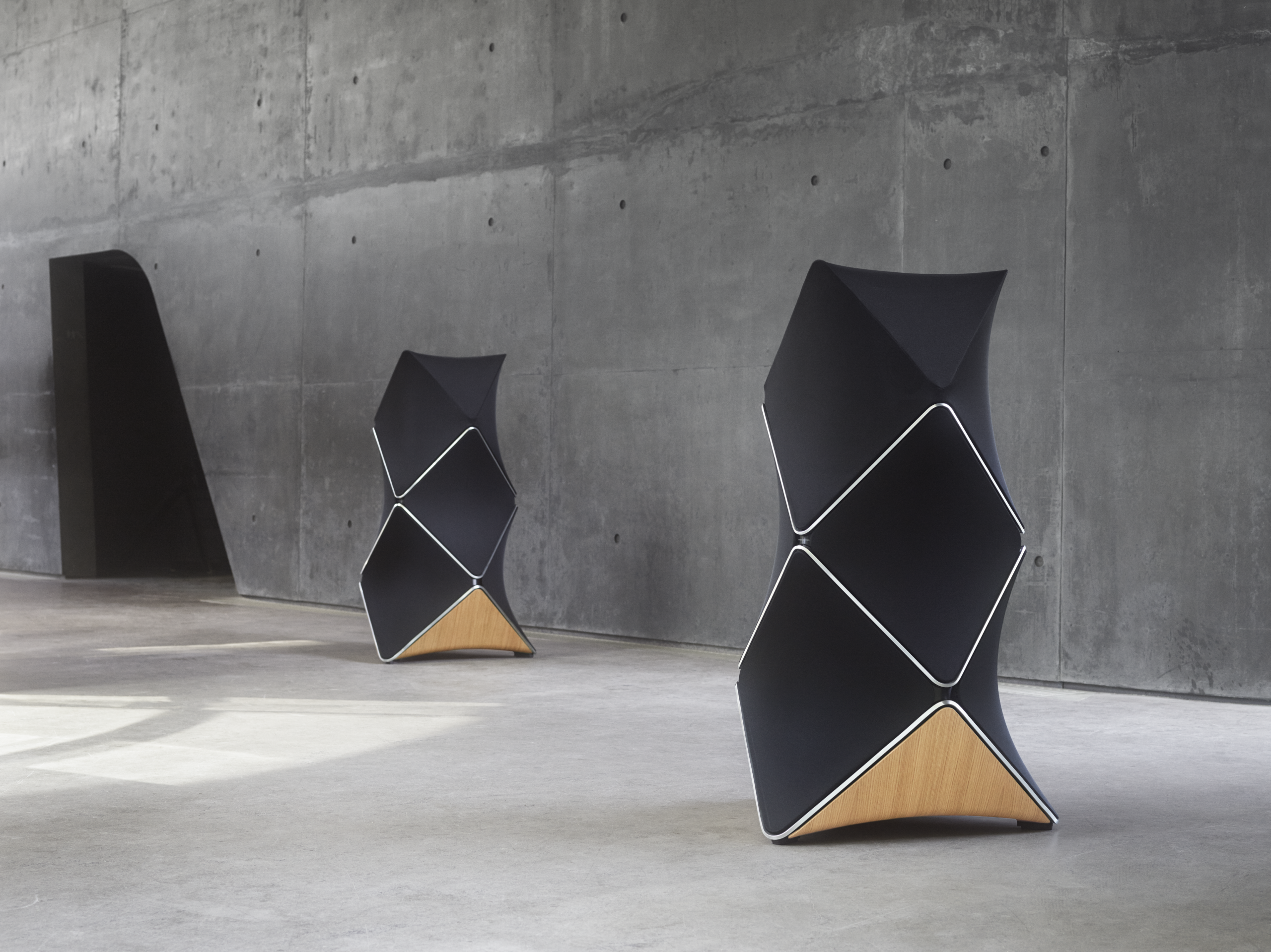 Pair of black Beolab 90 speakers, featuring a silver trim and an oak wood panel, in one piece